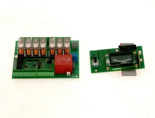 Schaltung mit mehreren Relais, darunter ein rotes Relais. Nebenplatine mit Display und Steuerungselementen. Produkt könnte Teil eines Bosch Regelungssystems sein.